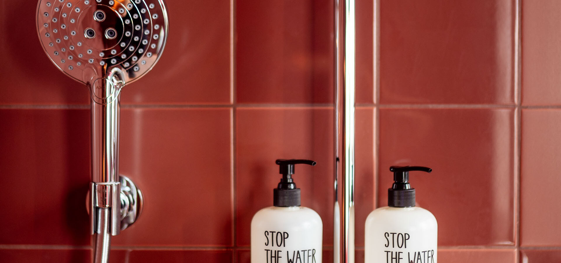 Detailbild der Dusche mit Duschkopf und Duschgel im KONCEPT HOTEL Josefine