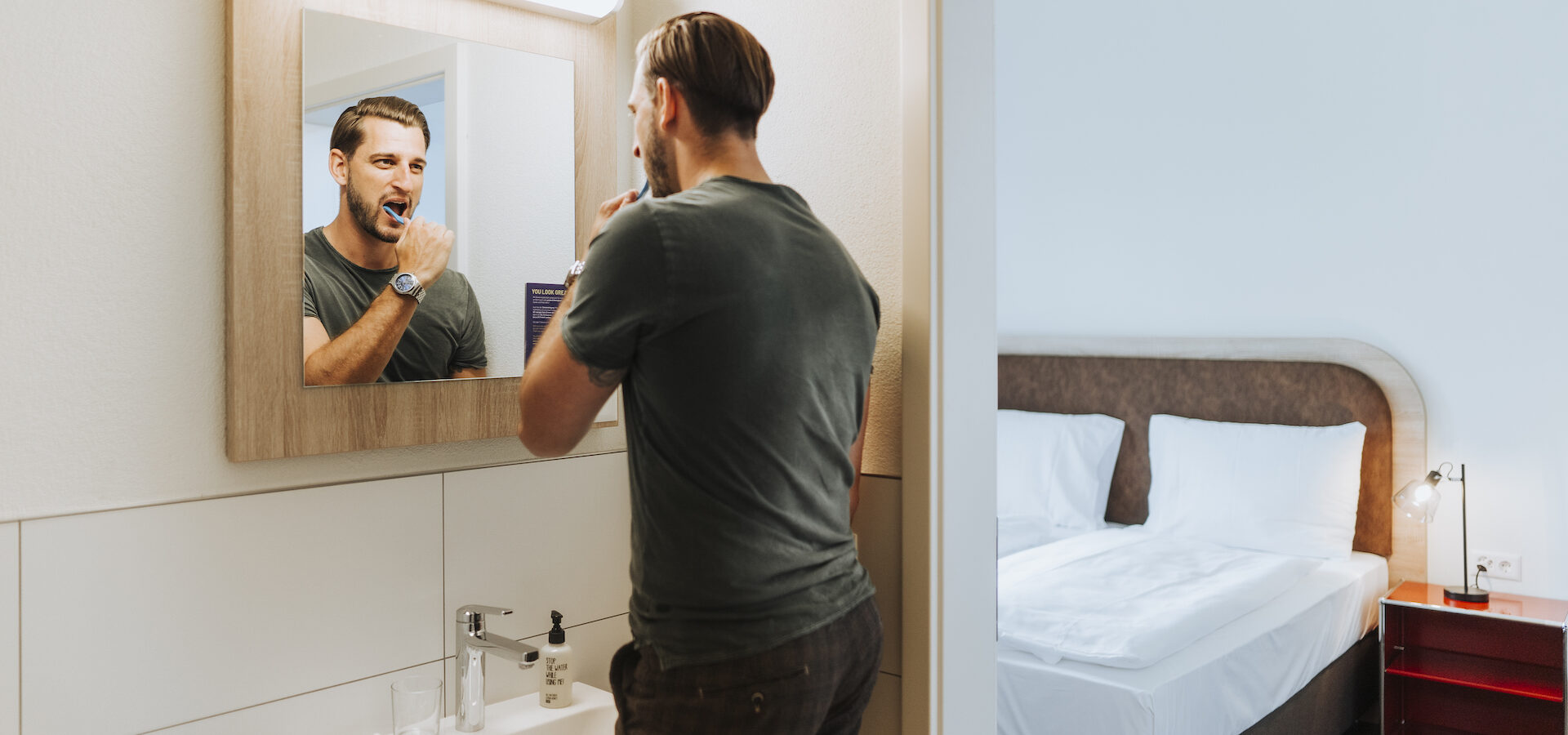 Mann putzt sich die Zähne im Badezimmer im Hotel Münsingen
