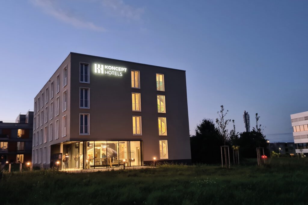 KONCEPT HOTEL Neue Horizonte in der Dämmerung mit beleuchtetem Schriftzug