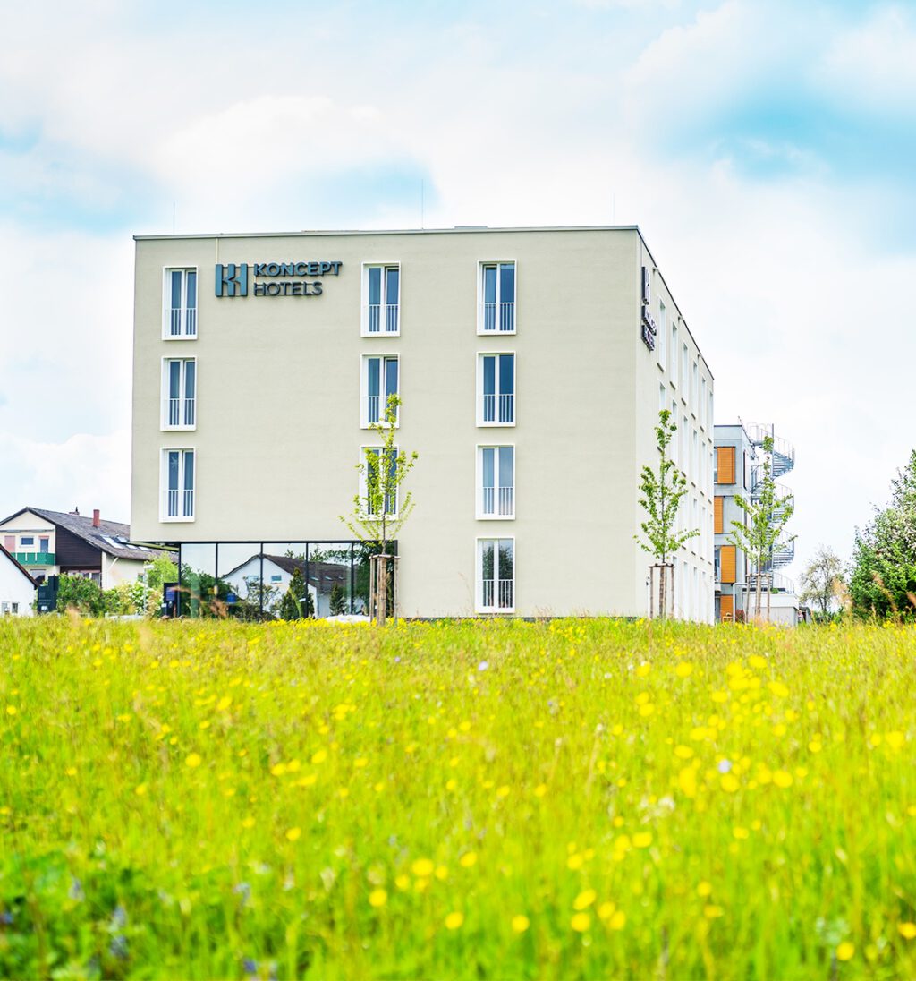 KONCEPT HOTEL Neue Horizonte Tübingen mit Blumenwiese im Vordergrund