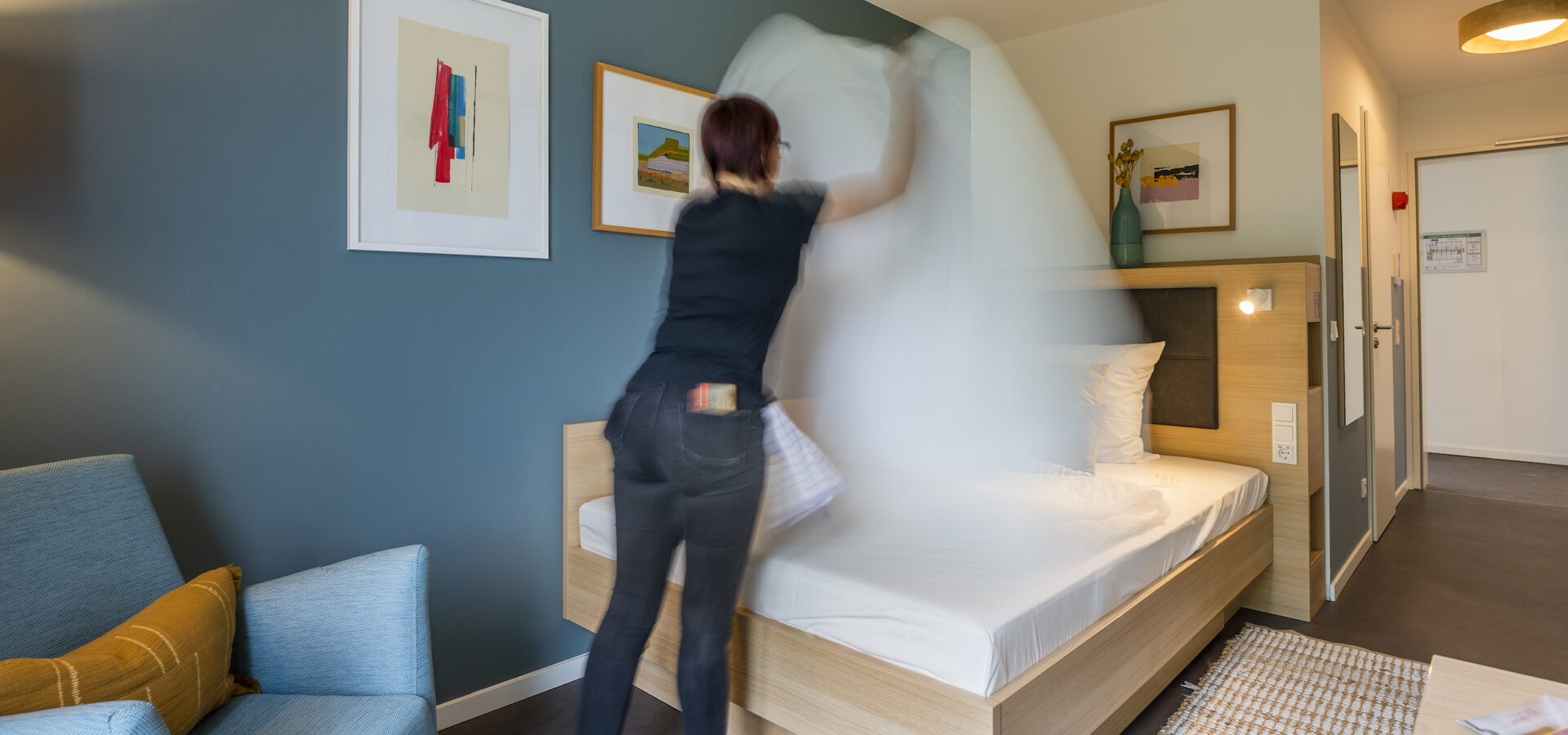Bett wird im Hotelzimmer gemacht
